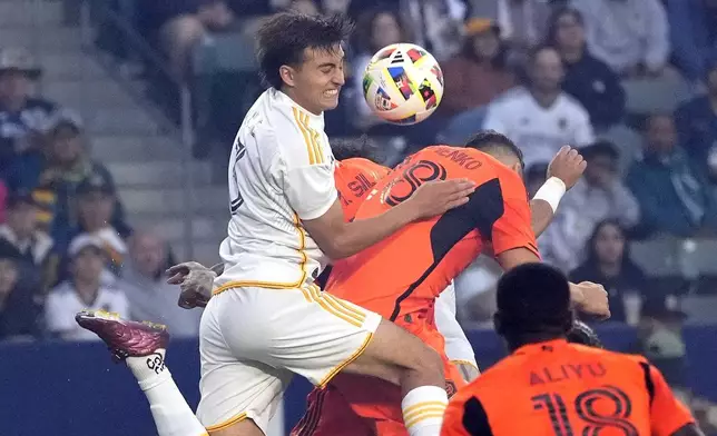 LA Galaxy defender Julián Aude, left, and Houston Dynamo defender Erik Sviatchenko, upper right try to head the ball during the first half of a Major League Soccer match Saturday, May 25, 2024, in Carson, Calif. (AP Photo/Mark J. Terrill)