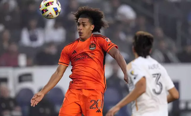 Houston Dynamo midfielder Adalberto Carrasquilla, left, heads the ball while LA Galaxy defender Julián Aude watches during the first half of a Major League Soccer match Saturday, May 25, 2024, in Carson, Calif. (AP Photo/Mark J. Terrill)
