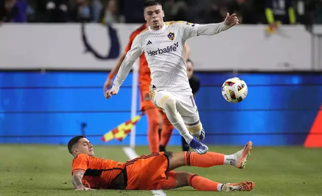 LA Galaxy forward Gabriel Pec, top, is tripped by Houston Dynamo defender Franco Escobar during the second half of a Major League Soccer match Saturday, May 25, 2024, in Carson, Calif. (AP Photo/Mark J. Terrill)