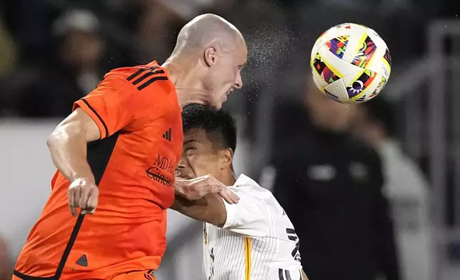 Houston Dynamo defender Brad Smith, heads the ball while pressured by LA Galaxy midfielder Daniel Aguirre during the second half of an MLS soccer match Saturday, May 25, 2024, in Carson, Calif. (AP Photo/Mark J. Terrill)