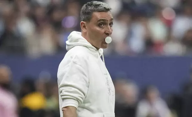 Vancouver Whitecaps coach Vanni Sartini blows a bubble as he watches from the sideline during the second half of the team's MLS soccer match against Inter Miami on Saturday, May 25, 2024, in Vancouver, British Columbia. (Darryl Dyck/The Canadian Press via AP)