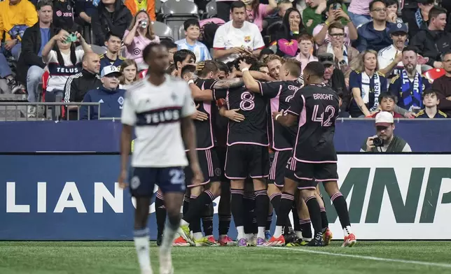 Inter Miami's Leonardo Campana (8) celebrates with teammates after scoring, as Vancouver Whitecaps' Ali Ahmed, foreground, walks away during the second half of an MLS soccer match Saturday, May 25, 2024, in Vancouver, British Columbia. (Darryl Dyck/The Canadian Press via AP)