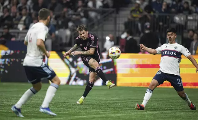 Inter Miami's Robert Taylor, center, kicks the ball past Vancouver Whitecaps' Mathias Laborda, right, and Ranko Veselinovic, front left, for a goal during the first half of an MLS soccer match, in Vancouver, on Saturday, May 25, 2024. (Darryl Dyck/The Canadian Press via AP)