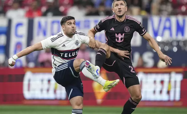 Vancouver Whitecaps' Brian White, left, and Inter Miami's Serhiy Kryvtsov vie for the ball during the first half of an MLS soccer match Saturday, May 25, 2024, in Vancouver, British Columbia. (Darryl Dyck/The Canadian Press via AP)