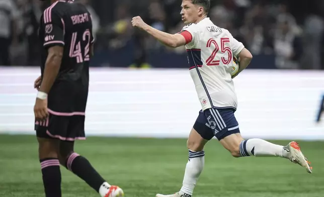Vancouver Whitecaps' Ryan Gauld (25) runs with the ball past Inter Miami's Yannick Bright (42) after scoring on a penalty kick during the second half of an MLS soccer match Saturday, May 25, 2024, in Vancouver, British Columbia. (Darryl Dyck/The Canadian Press via AP)