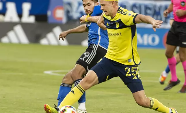 CF Montreal's Mathieu Choiniere, left, and Nashville SC's Walker Zimmerman vie for the ball during the first half of an MLS soccer match Saturday, May 25, 2024, in Montreal. (Peter McCabe/The Canadian Press via AP)