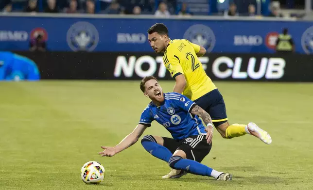 CF Montreal's Joel Waterman, bottom, falls after battling Nashville SC's Daniel Lovitz, top, during first-half MLS soccer match action in Montreal, Saturday, May 25, 2024. (Peter McCabe/The Canadian Press via AP)