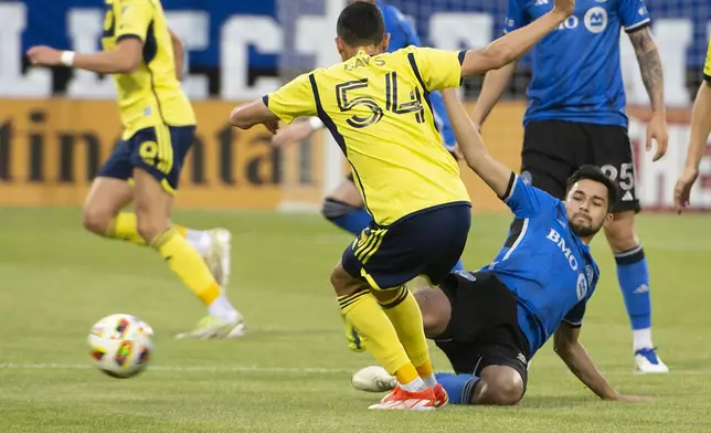 CF Montreal's Mathieu Choiniere, right, slides in to block a pass from Nashville SC's Sean Davis during the first half of an MLS soccer match Saturday, May 25, 2024, in Montreal. (Peter McCabe/The Canadian Press via AP)