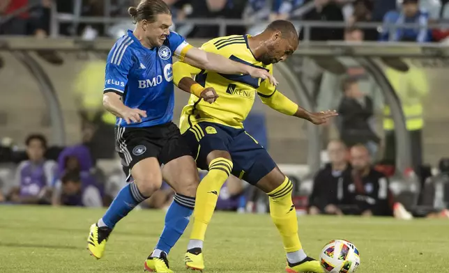 CF Montreal's Samuel Piette, left, and Nashville SC's Teal Bunbury vie for the ball during the second half of an MLS soccer match Saturday, May 25, 2024, in Montreal. (Peter McCabe/The Canadian Press via AP)