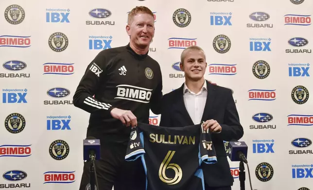 Philadelphia Union manager Jim Curtin, left, and new player Cavan Sullivan, 14, hold up Sullivan's No. 6 jersey during an MLS soccer news conference at Subaru Park in Chester, Pa., Thursday, May 9, 2024. (Jonathan Tannenwald/The Philadelphia Inquirer via AP