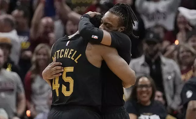 Cleveland Cavaliers guard Darius Garland, right, hugs teammate Donovan Mitchell (45) after hitting a 3-point basket in the second half of Game 7 of an NBA basketball first-round playoff series against the Orlando Magic, Sunday, May 5, 2024, in Cleveland. (AP Photo/Sue Ogrocki)