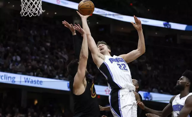 Orlando Magic forward Franz Wagner (22) shoots against Cleveland Cavaliers guard Max Strus during the second half of Game 5 of an NBA basketball first-round playoff series, Tuesday, April 30, 2024, in Cleveland. (AP Photo/Ron Schwane)