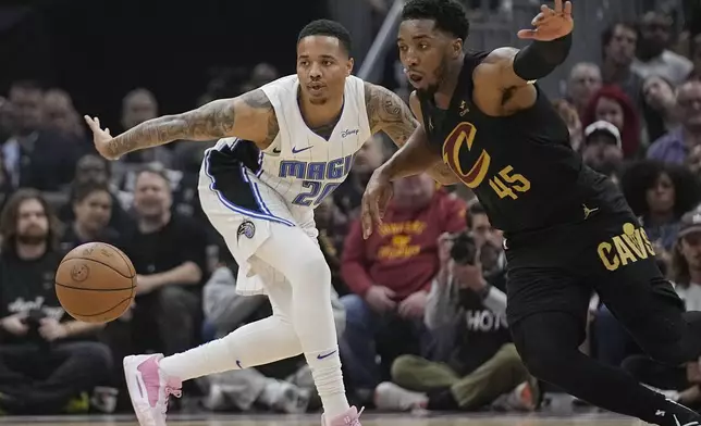 Orlando Magic guard Markelle Fultz (20) and Cleveland Cavaliers guard Donovan Mitchel (45) watch the ball in the first half of Game 7 of an NBA basketball first-round playoff series Sunday, May 5, 2024, in Cleveland. (AP Photo/Sue Ogrocki)