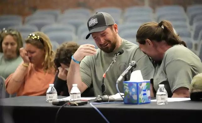 James Herling pauses his testimony while recalling the moment he realized the shooter was his brother-in-law, Robert Card, while testifying, Thursday, May 16, 2024, in Augusta, Maine, during a hearing of the independent commission investigating the law enforcement response to the mass shooting in Lewiston, Maine. Nicole Herling, sister of the shooter, cries on her husband's shoulder. (AP Photo/Robert F. Bukaty)