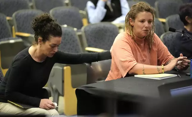 Cara Lamb, ex-wife of shooter Robert Card, is comforted as she testifies, Thursday, May 16, 2024, in Augusta, Maine, during a hearing of the independent commission investigating the law enforcement response to the mass shooting in Lewiston, Maine. (AP Photo/Robert F. Bukaty)