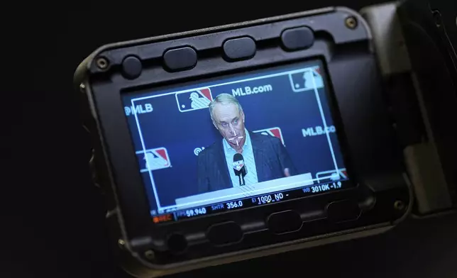 Major League Baseball commissioner Rob Manfred, displayed on a video monitor, speaks at a press conference following an owners meeting, Thursday, May 23, 2024, in New York. (AP Photo/Julia Nikhinson)