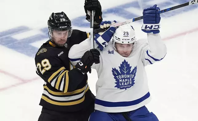 Boston Bruins' Parker Wotherspoon, left, battles Toronto Maple Leafs' Pontus Holmberg during the first period of Game 7 of an NHL hockey Stanley Cup first-round playoff series, Saturday, May 4, 2024, in Boston. (AP Photo/Michael Dwyer)