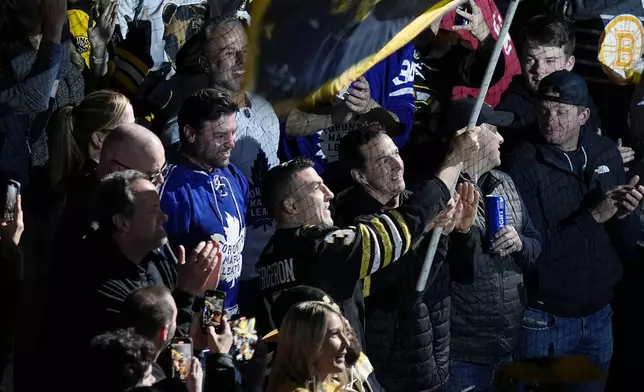 Former Boston Bruins Patrice Bergeron (37) waves a flag in the stands before Game 7 of an NHL hockey Stanley Cup first-round playoff series against the Toronto Maple Leafs, Saturday, May 4, 2024, in Boston. (AP Photo/Michael Dwyer)