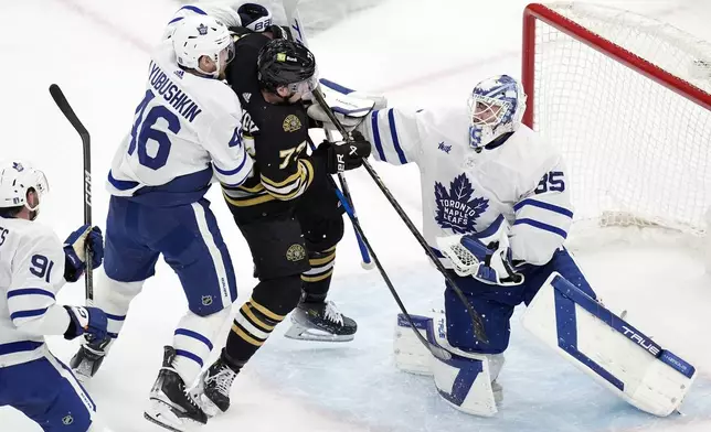 Toronto Maple Leafs' Ilya Lyubushkin (46) defends against Boston Bruins' Charlie McAvoy (73) in front of Ilya Samsonov (35) during the first period of Game 7 of an NHL hockey Stanley Cup first-round playoff series, Saturday, May 4, 2024, in Boston. (AP Photo/Michael Dwyer)