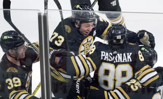 Boston Bruins' David Pastrnak (88) celebrates his goal with Morgan Geekie (39), Charlie McAvoy (73) and Brandon Carlo (25) in overtime during Game 7 of an NHL hockey Stanley Cup first-round playoff series against the Toronto Maple Leafs, Saturday, May 4, 2024, in Boston. (AP Photo/Michael Dwyer)