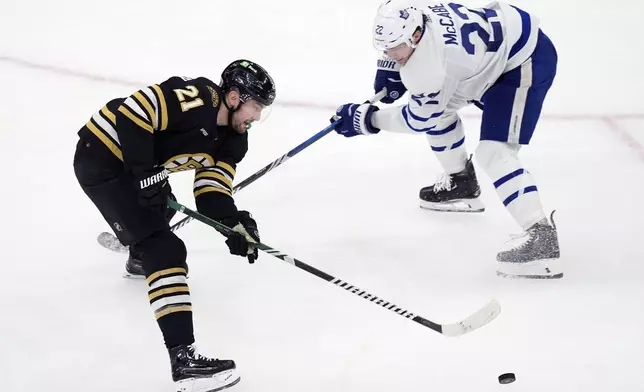 Toronto Maple Leafs' Jake McCabe (22) battles Boston Bruins' James van Riemsdyk (21) for the puck during the first period of Game 7 of an NHL hockey Stanley Cup first-round playoff series, Saturday, May 4, 2024, in Boston. (AP Photo/Michael Dwyer)
