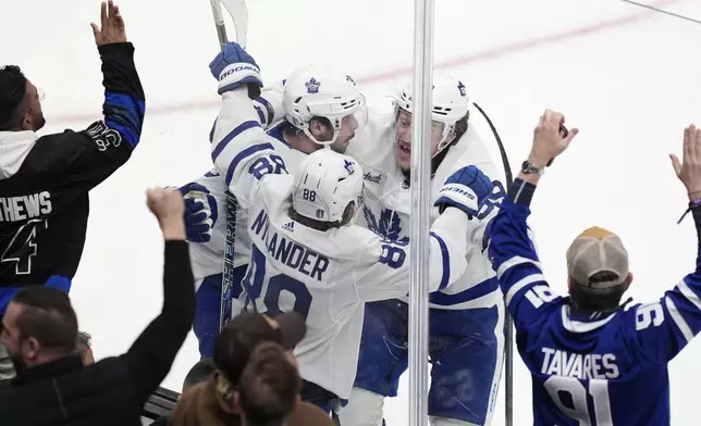 Toronto Maple Leafs' William Nylander (88) celebrates his goal with Auston Matthews (34) and Tyler Bertuzzi (59) during the third period of Game 7 of an NHL hockey Stanley Cup first-round playoff series against the Boston Bruins, Saturday, May 4, 2024, in Boston. (AP Photo/Michael Dwyer)