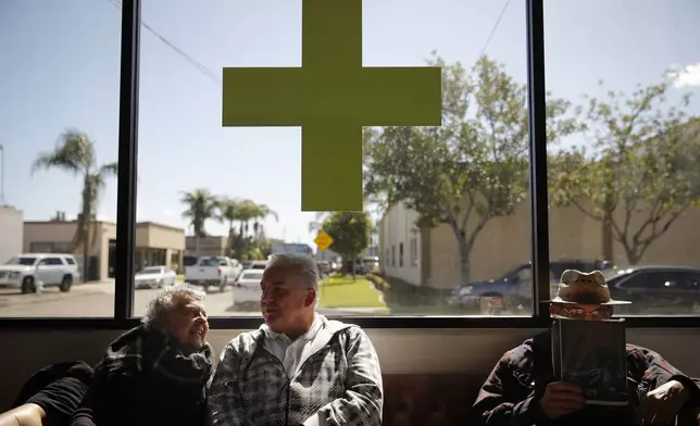 FILE - Kay Nelson, left, and Bryan Grode, retried seniors from Laguna Woods Village, chat in the lobby of Bud and Bloom cannabis dispensary while waiting for a free shuttle to arrive in Santa Ana, Calif., Feb. 19, 2019. A federal proposal to reclassify marijuana as a less dangerous drug has raised the hopes of some pot backers that more states will embrace cannabis. (AP Photo/Jae C. Hong, File)
