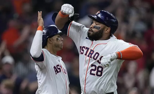 Houston Astros' Jon Singleton (28) celebrates with Jeremy Peña, left, after hitting a go-ahead two-run home run during the seventh inning of a baseball game against the Seattle Mariners, Sunday, May 5, 2024, in Houston. (AP Photo/Kevin M. Cox)