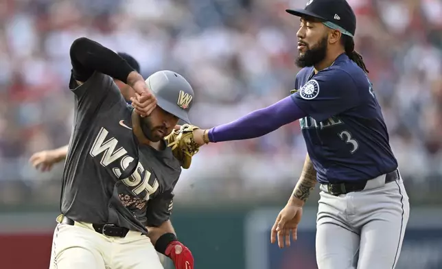 Washington Nationals' Joey Gallo, left, is tagged out by Seattle Mariners shortstop J.P. Crawford (3) on a steal-attempt of second base during the seventh inning of a baseball game, Saturday, May 25, 2024, in Washington. (AP Photo/John McDonnell)