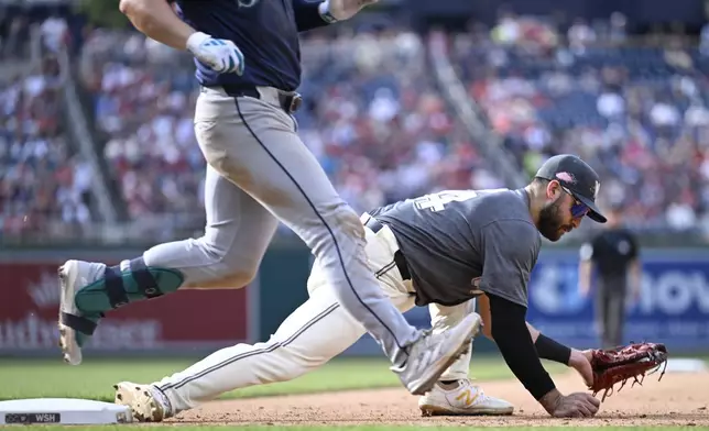 Washington Nationals first baseman Joey Gallo, right, hangs onto a wide throw to put out Seattle Mariners Ty France, left, during the seventh inning of a baseball game, Saturday, May 25, 2024, in Washington. (AP Photo/John McDonnell)