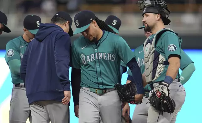 Seattle Mariners starter Luis Castillo, center, leaves the mound during a pitching change in the seventh inning of a baseball game against the Minnesota Twins, Monday, May 6, 2024, in Minneapolis. (AP Photo/Abbie Parr)