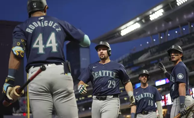 Seattle Mariners' Cal Raleigh (29) celebrates with teammates after hitting a grand slam during the seventh inning of a baseball game against the Minnesota Twins,Tuesday, May 7, 2024, in Minneapolis. (AP Photo/Abbie Parr)