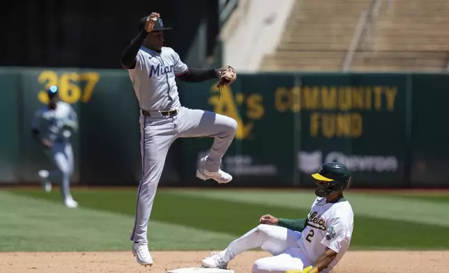 Oakland Athletics' Darell Hernaiz, right, slides safely at second next to Miami Marlins shortstop Tim Anderson during the fourth inning of a baseball game, Sunday, May 5, 2024, in Oakland, Calif. Athletics' Kyle McCann reached first on the throwing error by Marlins' Josh Bell. (AP Photo/Godofredo A. Vásquez)