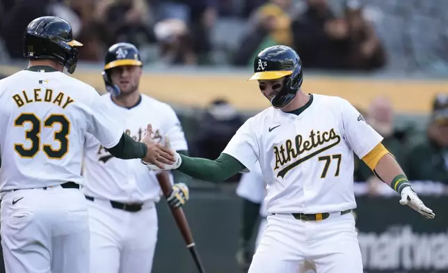 Oakland Athletics' Brett Harris (77) celebrates with JJ Bleday (33) after hitting a two-run home run against the Miami Marlins during the sixth inning of a baseball game Saturday, May 4, 2024, in Oakland, Calif. (AP Photo/Godofredo A. Vásquez)