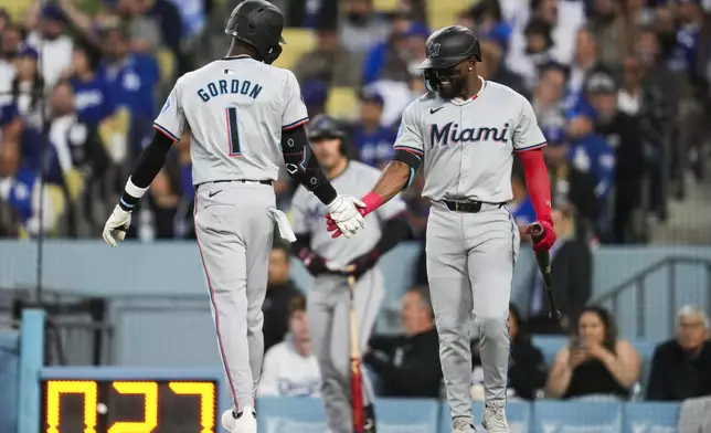 Miami Marlins' Nick Gordon (1) celebrates with Vidal Bruján after hitting a home run during the second inning of a baseball game against the Los Angeles Dodgers in Los Angeles, Monday, May 6, 2024. (AP Photo/Ashley Landis)