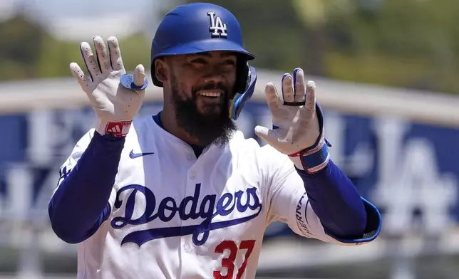 Los Angeles Dodgers' Teoscar Hernández gestures to teammates in the dugout as he rounds third after hitting a two-run home run during the sixth inning of a baseball game against the Miami Marlins Wednesday, May 8, 2024, in Los Angeles. (AP Photo/Mark J. Terrill)