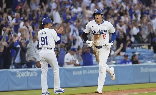 Los Angeles Dodgers' Shohei Ohtani, right, celebrates as he scores on a grand slam by Max Muncy against the Miami Marlins during the first inning of a baseball game Tuesday, May 7, 2024, in Los Angeles. (AP Photo/Marcio Jose Sanchez)