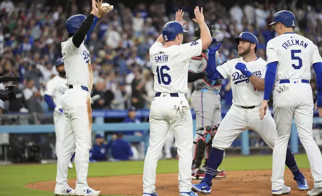 Los Angeles Dodgers' Max Muncy, second from right, celebrates his grand slam with teammates at home plate, during the first inning of the team's baseball game against the Miami Marlins, Tuesday, May 7, 2024, in Los Angeles. (AP Photo/Marcio Jose Sanchez)