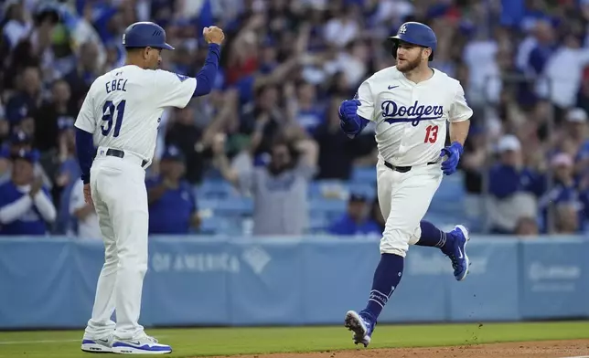 Los Angeles Dodgers' Max Muncy celebrates with third base coach Dino Ebel as he runs the bases after hitting a grand slam against the Miami Marlins during the first inning of a baseball game Tuesday, May 7, 2024, in Los Angeles. (AP Photo/Marcio Jose Sanchez)