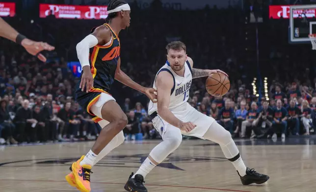 Dallas Mavericks guard Luka Doncic, right, works the floor against Oklahoma City Thunder guard Shai Gilgeous-Alexander during the first half of Game 5 of an NBA basketball second-round playoff series, Wednesday, May 15, 2024, in Oklahoma City. (AP Photo/Nate Billings)