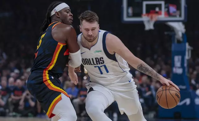 Dallas Mavericks guard Luka Doncic (77) drives against Oklahoma City Thunder guard Luguentz Dort during the first half of Game 5 of an NBA basketball second-round playoff series, Wednesday, May 15, 2024, in Oklahoma City. (AP Photo/Nate Billings)