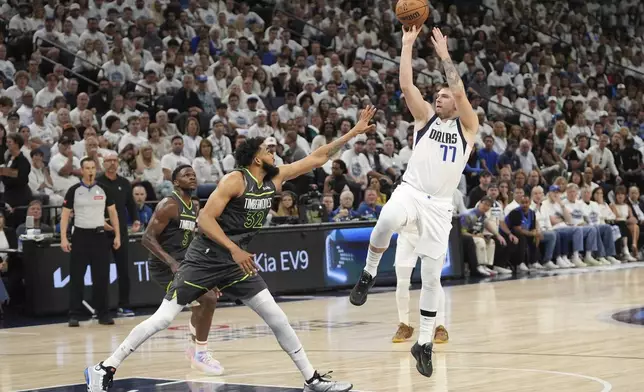 Dallas Mavericks guard Luka Doncic (77) shoots over Minnesota Timberwolves center Karl-Anthony Towns (32) during the first half of Game 5 of the Western Conference finals in the NBA basketball playoffs, Thursday, May 30, 2024, in Minneapolis. (AP Photo/Abbie Parr)