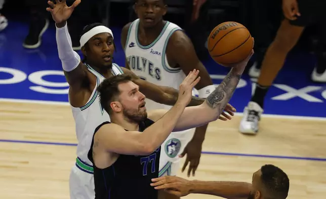 Dallas Mavericks guard Luka Doncic (77) shoots against the Minnesota Timberwolves during the second half of Game 2 of the NBA basketball Western Conference finals, Friday, May 24, 2024, in Minneapolis. (AP Photo/Bruce Kluckhohn)