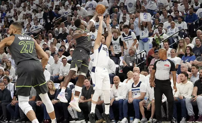 Dallas Mavericks guard Luka Doncic (77) shoots a 3-pointer over Minnesota Timberwolves guard Anthony Edwards (5) during the first half of Game 5 of the Western Conference finals in the NBA basketball playoffs, Thursday, May 30, 2024, in Minneapolis. (AP Photo/Abbie Parr)