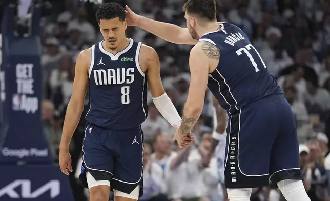 Dallas Mavericks guard Josh Green (8) is encouraged by teammate Luka Doncic (77) during the second half in Game 1 of the NBA basketball Western Conference finals against the Minnesota Timberwolves, Wednesday, May 22, 2024, in Minneapolis. (AP Photo/Abbie Parr)