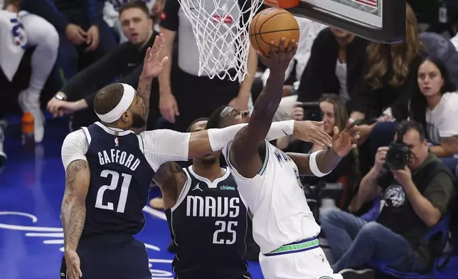 Minnesota Timberwolves guard Anthony Edwards (5) is fouled by Dallas Mavericks center Daniel Gafford (21) as he drives to the basket during Game 1 of the NBA basketball Western Conference finals, Wednesday, May 22, 2024, in Minneapolis. (AP Photo/Matt Krohn)