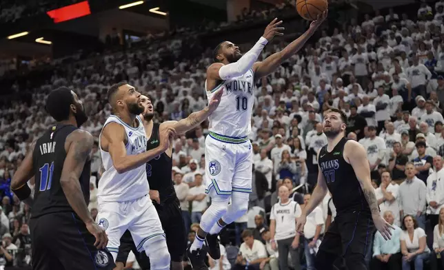 Minnesota Timberwolves guard Mike Conley (10) shoots over Dallas Mavericks guard Luka Doncic (77) during the second half of Game 2 of the NBA basketball Western Conference finals, Friday, May 24, 2024, in Minneapolis. (AP Photo/Abbie Parr)