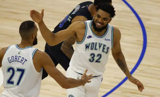 Minnesota Timberwolves' Rudy Gobert (27) and Karl-Anthony Towns (32) celebrate after a play against the Dallas Mavericks during the second half of Game 2 of the NBA basketball Western Conference finals, Friday, May 24, 2024, in Minneapolis. (AP Photo/Bruce Kluckhohn)