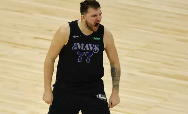 Dallas Mavericks guard Luka Doncic (77) celebrates after making a 3-point shot to take the lead against the Minnesota Timberwolves with seconds left during the second half of Game 2 of the NBA basketball Western Conference finals, Friday, May 24, 2024, in Minneapolis. (AP Photo/Bruce Kluckhohn)