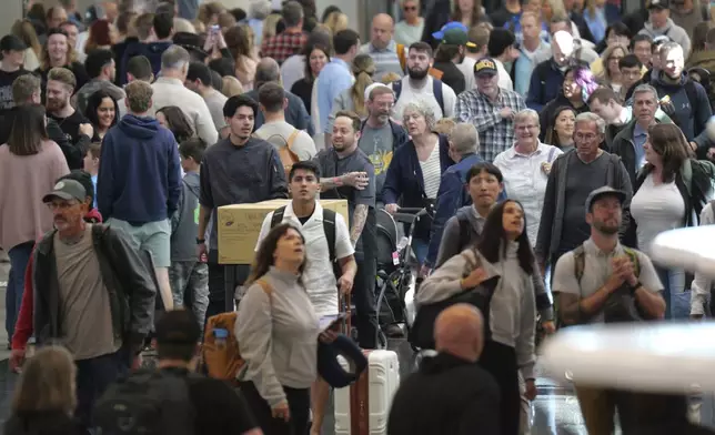 Travelers walk through Salt Lake City International Airport Friday, May 24, 2024, in Salt Lake City. A record number of Americans are expected to travel over the 2024 Memorial Day holiday. (AP Photo/Rick Bowmer)